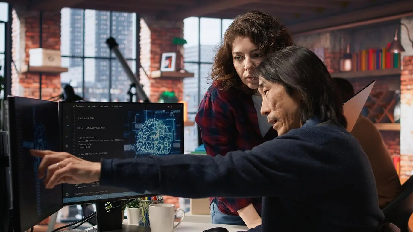 Colleghi di una startup impegnati nel testing del codice e nell'assicurazione della qualità sui dispositivi.